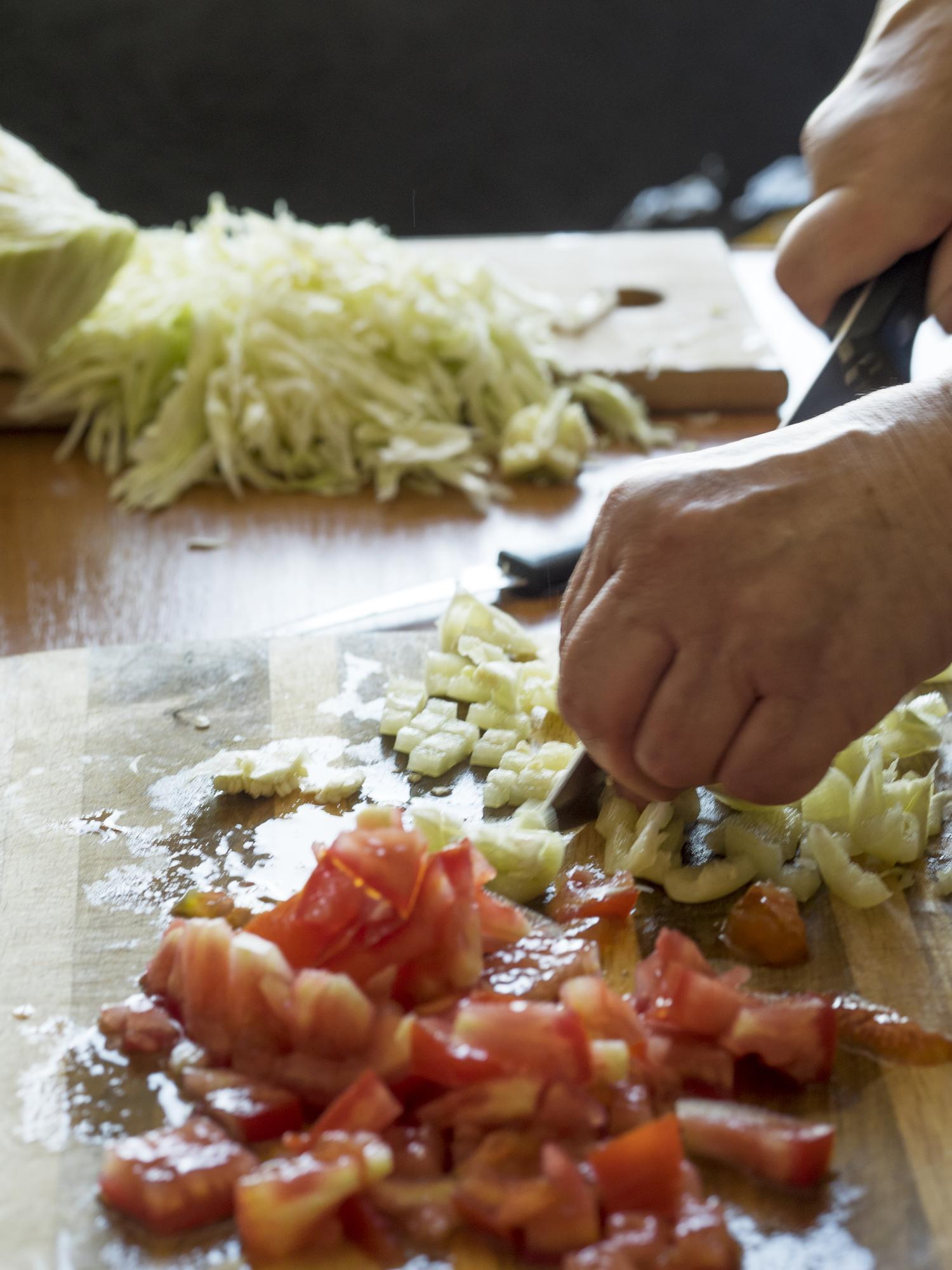Small batch kitchen with chef preparing vegetables